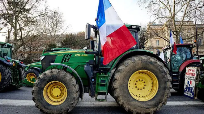 Um trator francês com a bandeira tricolor em frente à Assembleia Nacional, em Paris