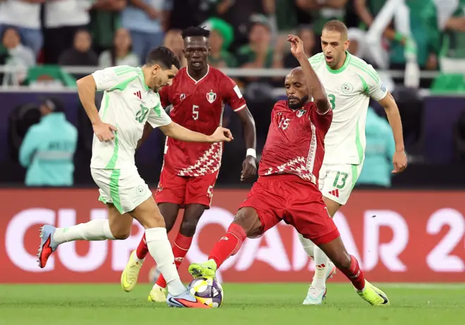 صراع على الكرة بين يوسف عطال، لاعب الجزائر، مع اللاعب السوداني صلاح عادل ضمن منافسات المجموعة الرابعة من كأس العرب لكرة القدم في قطر