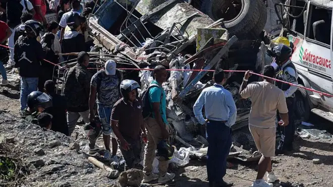 Varios rescatistas y transeuntes están alrededor de los escombros que quedaron del atentado con explosivos en Colombia.