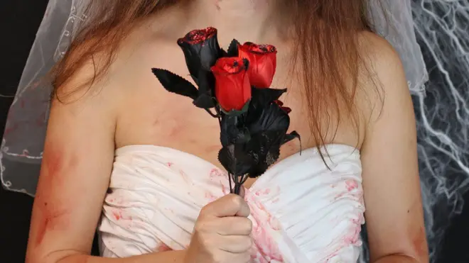 Bride carry rose with fake blood stained dress