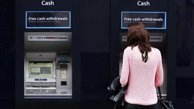 Một phụ nữ đứng trước ATM