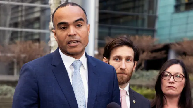 Генеральный прокурор штата Вашингтон Ник Браун (слева) выступает перед зданием суда