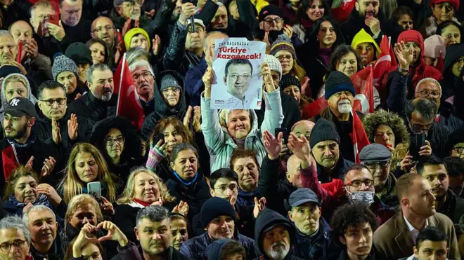 CHP'nin Saraçhane mitingine katılan kalabalık. Bir kişi, elinde İmamoğlu'nun resmini taşıyor. 