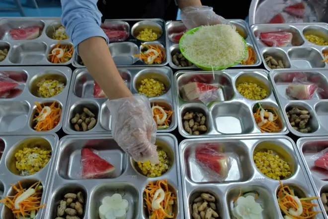 Pekerja menata menu makanan saat proses pemorsian di sebuah Satuan Pelayanan Pemenuhan Gizi (SPPG). 