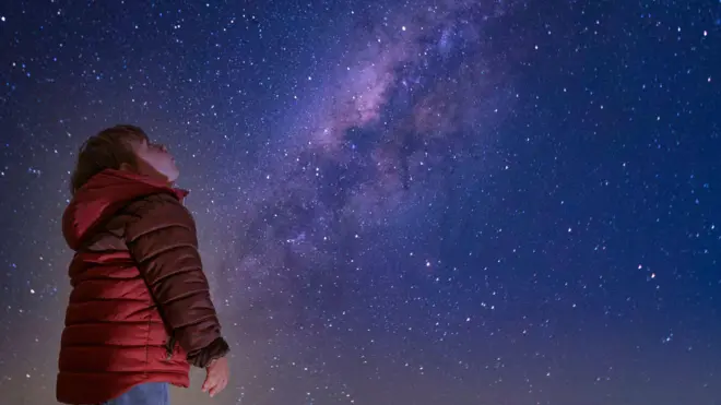 Gece gökyüzüne bakan bir çocuk
