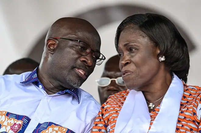 Charles Blé Goudé (à gauche) porte des lunettes parle dans les oreilles de Mme Simone Gbagbo qui a un ruban blanc autour du coup