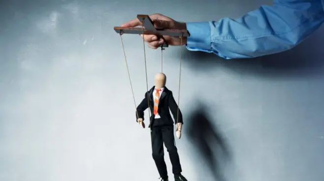 Une main manipulant un pantin