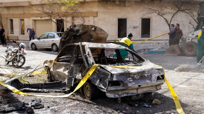 باقیماندههای یک خودرو پس از حمله هوایی مشترک اسرائیل و ایالات متحده به ساختمانی در تهران، ایران در ۲۸ فوریه ۲۰۲۶ دیده میشود، که نشاندهنده خرابی و آثار مخرب ناشی از این حمله است.