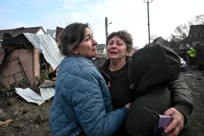 Một phụ nữ bật khóc ôm chầm lấy một phụ nữ khác và một cậu bé sau vụ pháo kích của Nga tại Zaporizhzhia, Ukraine, ngày 19 tháng 12 năm 2025.