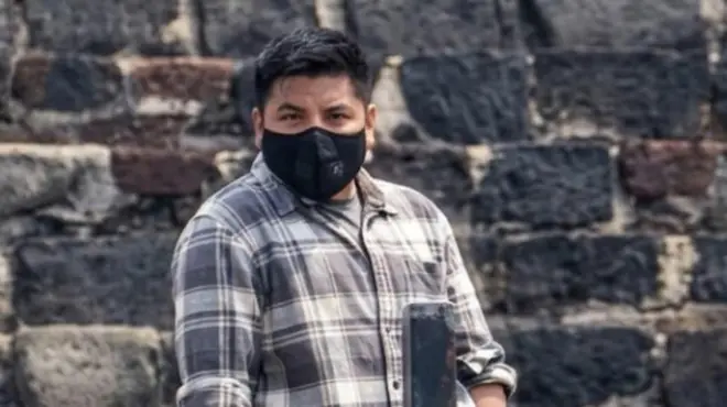 Foto de um homem usando uma máscara preta na boca