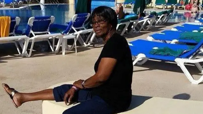 Hyacinth Gage, uma mulher negra sentada numa cadeira à beira de piscina