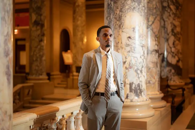 Musharax Cumar Faatix oo xidhan suudh iyo taay cadeys ah oo gacmaha jeebka kula jira