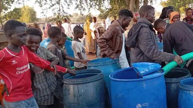 رجال وشباب وسيدات يحاولون الحصول على بعض الماء