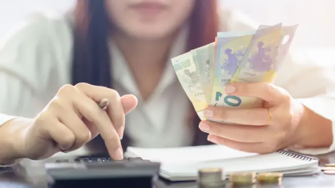 صورة لسيدة تحصي بعض الاموال