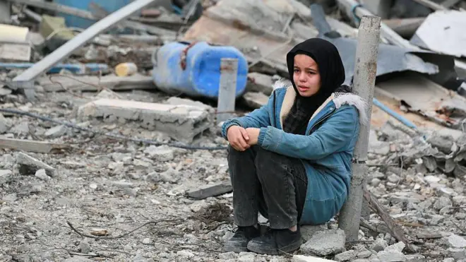 Una niña entre las ruinas de edificios en Gaza.