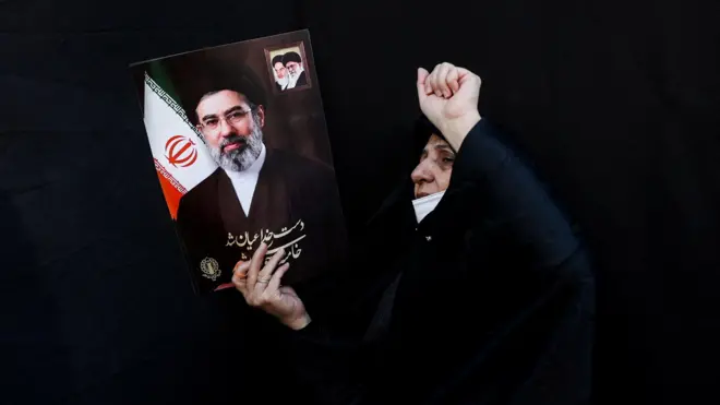 عکس مجتبی خامنه‌ای در دست یک زن هوادار جمهوری اسلامی