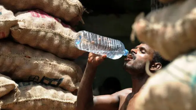 කුලී රැකියාවේ නිරත පුද්ගලයෙකු බෝතලයකින් ජලය පානය කරමින්