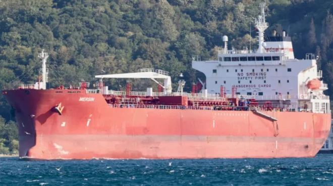 Ubwato Mersin muri mu mazi, inyuma haboneka igikumbi c'ibiti