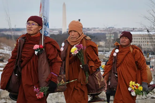 With the Washington Monument in the background, Buddhist monks continue their March for Peace on February 09, 2026 in Arlington, Virginia. A group of 18 monks began a 2,300-mile march on October 26 in Fort Worth, Texas, to raise awareness of “peace, loving kindness and compassion” in the United States and the world, and will arrive in the nation's capital tomorrow.