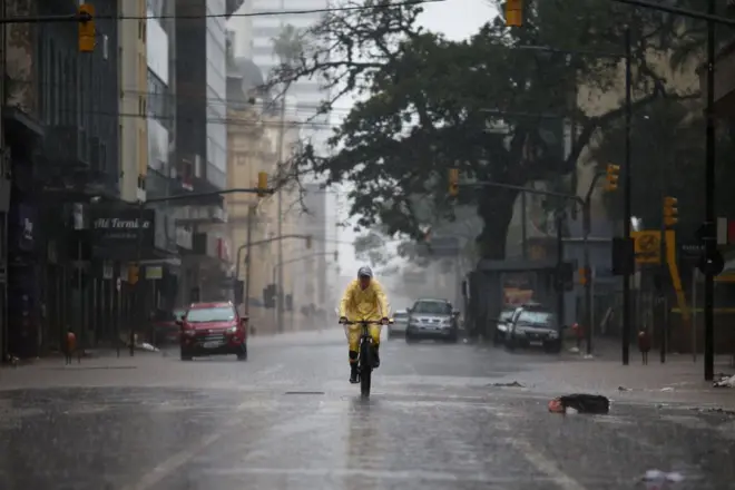 Pessoa andando de bicicleta em meio à chuva