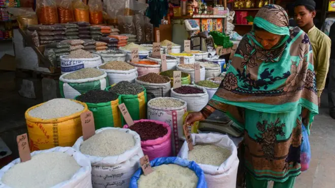 پاکستان کے شہر کراچی میں ایک خاتون چاول کی قیمت دیکھ رہی ہیں