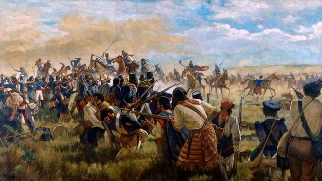 A imagem retrata uma cena de batalha em campo aberto, com dezenas de soldados armados com rifles e baionetas avançando e se protegendo enquanto a cavalaria investe ao fundo. A fumaça, a poeira e a movimentação intensa reforçam o clima de confronto, sob um céu parcialmente nublado que domina a paisagem.