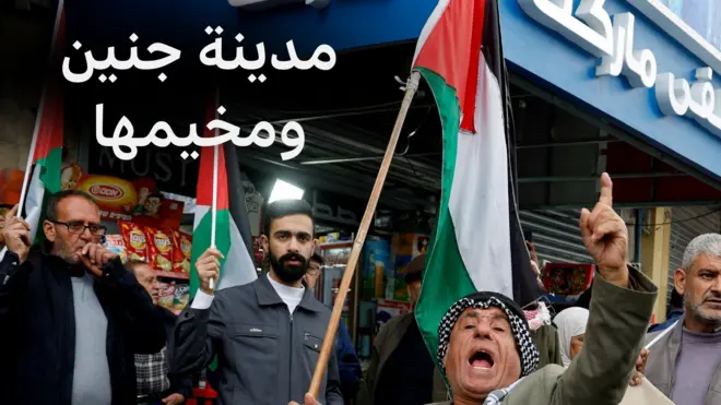 رجل فلسطيني يحمل العلم في مخيم جنين