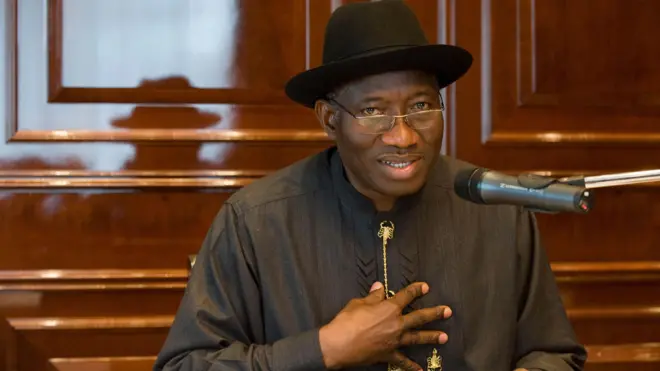 Ọmọwe Goodluck Jonathan, aarẹ Naijiria tẹlẹ, o de fila akẹtẹ sori, o logo soju rẹ, o wọsọ alawọ eeru, o si fi ọwọ rẹ si aya.