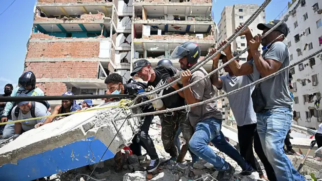 Hombres tratando de levantar escombros