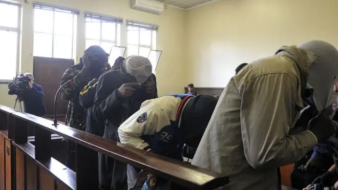 The five suspects flesh-eating case cover their faces during their appearance at the Estcourt Magistrates Court on August 28, 2017 in Estcourt, South Africa.