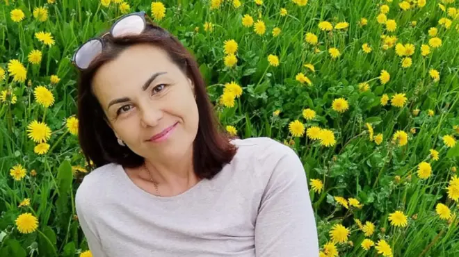 Женщина сидит на поле из одуванчиков