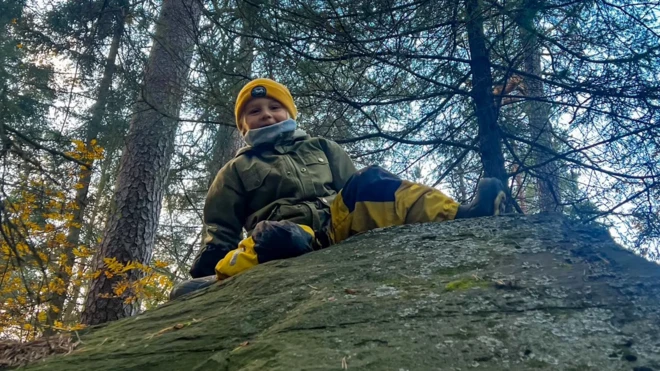 Garoto brincando na floresta