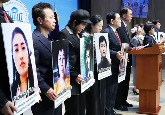 탈북민과 북한인권단체 관계자들이 강제북송 탈북민의 사진을 들고 있다