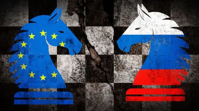 Ушбу концептуал тасвирда геосиёсий ёки стратегик қарама-қаршилик эскирган шахмат тахтасида бир-бирига рўпара қўйилган икки от фигураси орқали ифодаланган. Чап томондаги отга Европа Иттифоқи байроғи (кўк фонда сариқ юлдузлар), ўнг томондагисига эса Россия байроғи (оқ, кўк ва қизил горизонтал чизиқлар) туширилган. Шахмат тахтасининг эскирган кўриниши ва фигуралар устидаги байроқлар бу икки томон ўртасидаги муносабатлар узоқ тарихга эга ва кескин эканини англатади