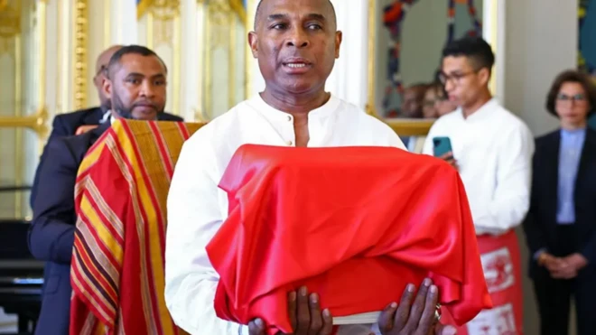 Oṣiṣẹ ijọba Madagascar kan gbe apoti ti wọn fi aṣọ pupa we nibi eto ti ileeṣẹ ijọba France to n ri si ọrọ aṣa ti da agbari Ọba Toera pada.