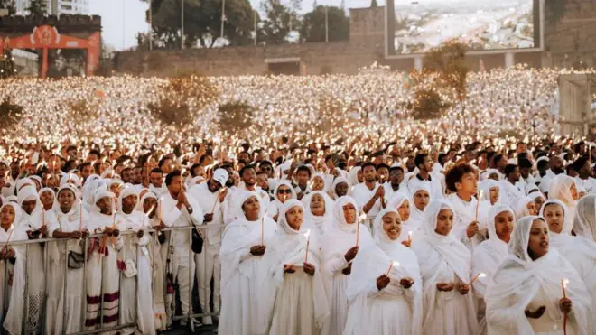 ነጭ ለብሰው የሚነድ ጧፍ የያዙ ሴቶች