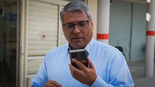 Ata Abu Madighem looking at his phone