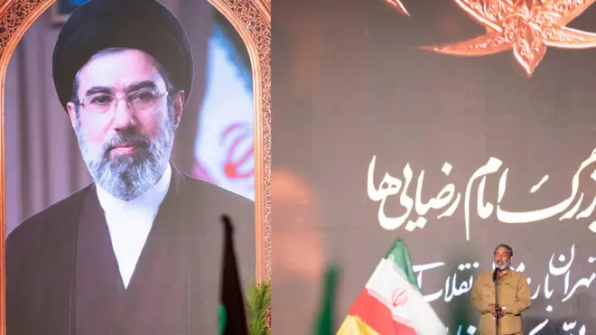 حسين يكتا، قائد كبير في الحرس الثوري الإسلامي، يتحدث إلى مؤيدين للحكومة بجانب صورة للمرشد الأعلى الإيراني آية الله مجتبى خامنئي خلال تجمع حكومي في وسط طهران، إيران، في 29 أبريل/ نيسان 2026. 