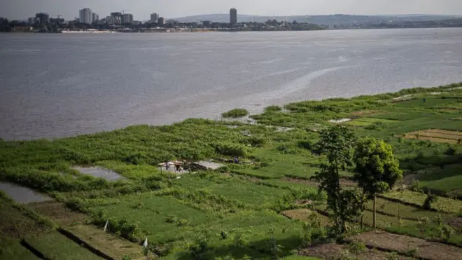 Abantu barimo guhinga ku nkombe y'uruzi Congo i Brazzaville, ku itariki ya 26 Ukwakira (10) mu 2023, mu gihe ku rundi ruhande rw'uruzi haboneka umurwa mukuru Kinshasa wa Repubulika ya Demokarasi ya Congo. 