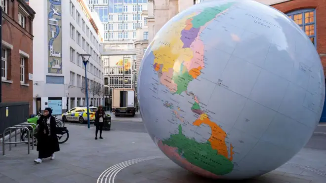 Turner Ödüllü sanatçı Mark Wallinger'ın London School of Economics kampüsünde sergilenen "Tersine Dönmüş Dünya" adlı eseri, ters çevrilmiş siyasi bir Dünya küresi heykeli. Yapı Kuzey Kutbu üzerinde duran bir küreyi tasvir ediyor ve Mart 2019'da açıldı.