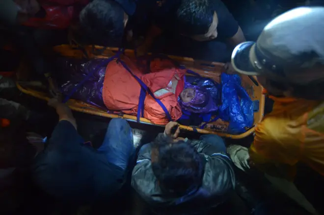 An Indonesian rescue team evacuates a survivor of the Mount Marapi eruption in Agam, West Sumatra province, Indonesia