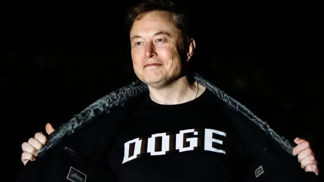 Илон Маск в футболке с надписью DOGE