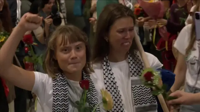 アテネ空港に到着したトゥーンベリ氏と活動家ら。白いTシャツを着て、肩にパレスチナの伝統的な黒と白のスカーフ「クーフィーヤ」をかけている。手には支援者から渡された花を持っている