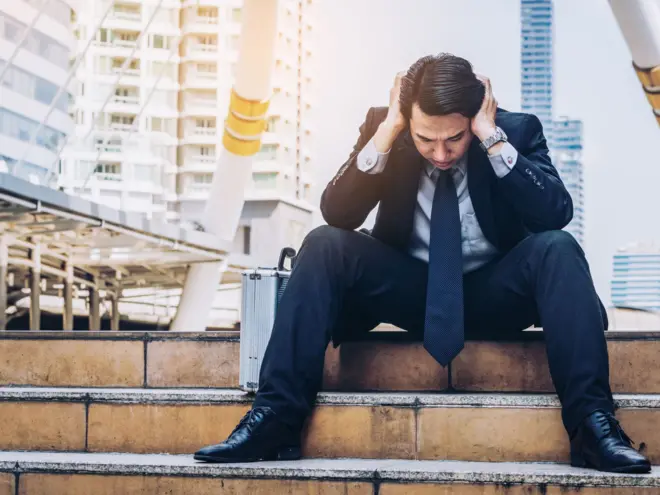 විරැකියාව හේතුවෙන් පඩිපෙළක් මත බලාපොරොත්තු රහිතව වාඩි වී සිටින මංමුලා සහගත තරුණයෙකුගේ පින්තූරයක්.