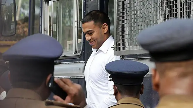 Former Sri Lankan president Mahinda Rajapaksa's second son Yoshitha Rajapaksa (C) arrives at a court to appear before a magistrate in the Colombo suburb of Kaduwela on February 11, 2016. Navy officer Yoshitha Rajapaksa, 27, was remanded in custody for two weeks after being arrested at the end of January on a charge of money laundering, police and court officials said. AFP PHOTO / Ishara S. KODIKARA (Photo by Ishara S.KODIKARA / AFP) (Photo by ISHARA S.KODIKARA/AFP via Getty Images)