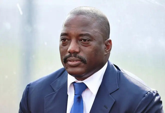 Joseph Kabila costume bleu avec une cravate bleue claire.