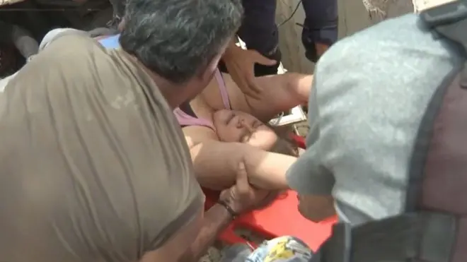 Mujer siendo rescatada de escombros