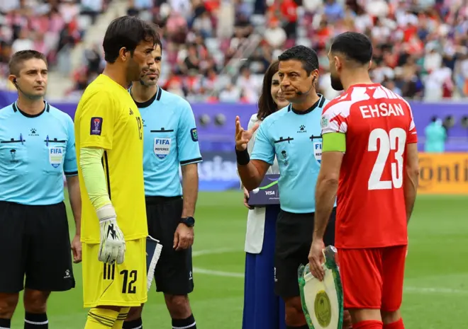 لاعبو المنتخبين الأردني والعراقي رفقة الطاقم التحكيمي قبل بداية مباراة جمعتهما في كأس آسيا 2023