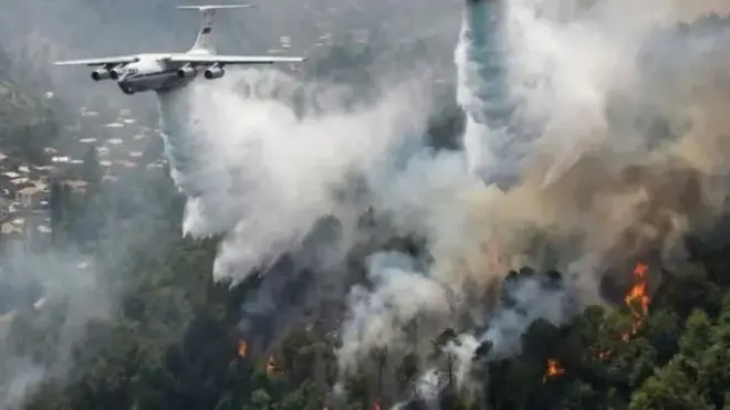 هواپیمای اطفای حریق بالای آتش‌سوزی جنگل