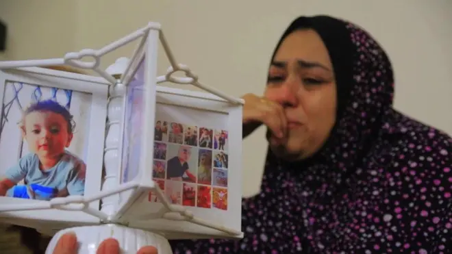 Nour is crying as she looks at pictures of her family